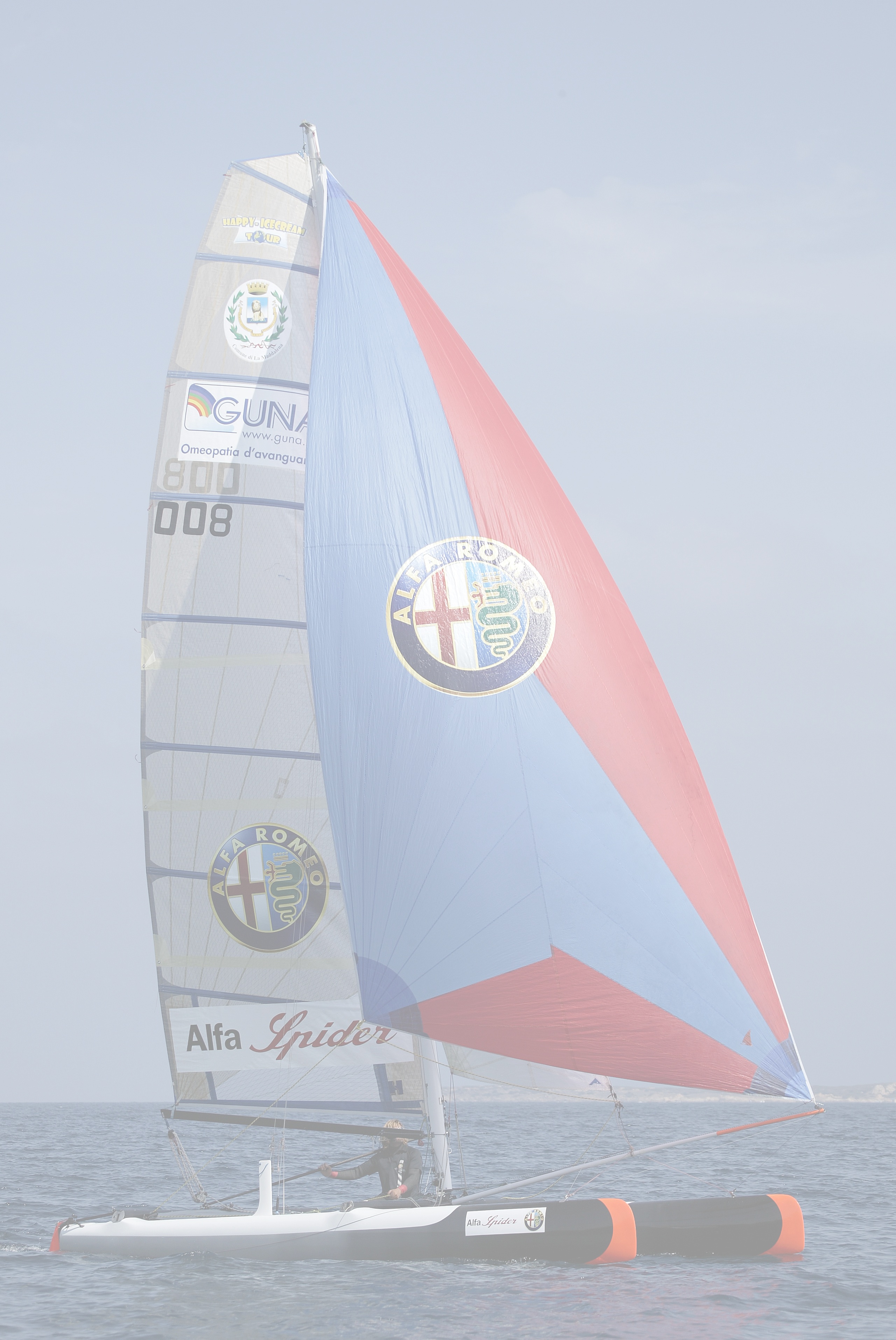 Catamarano con vela colorata in navigazione